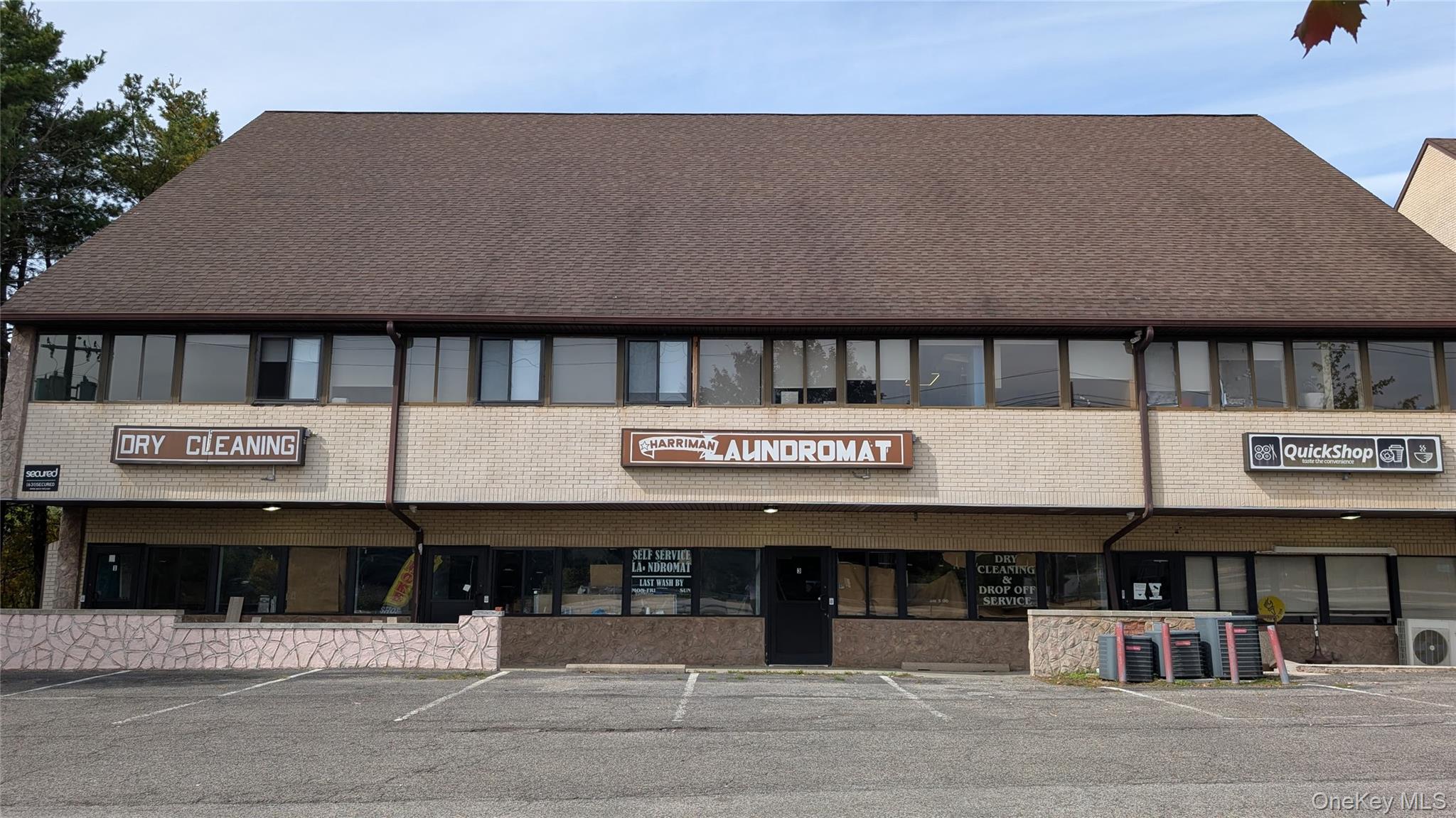 View of building exterior featuring uncovered parking