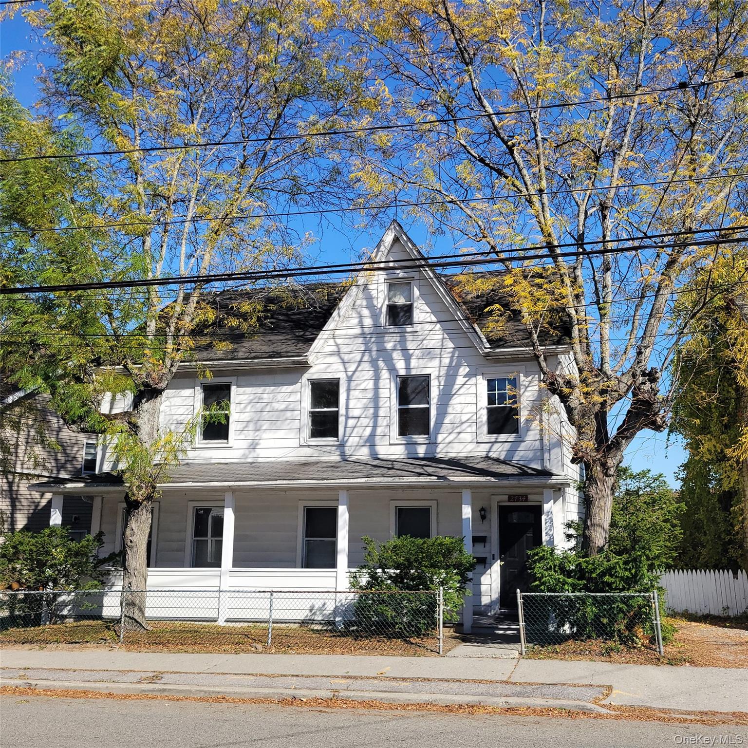View of front of house featuring a fenced front yard, and porch