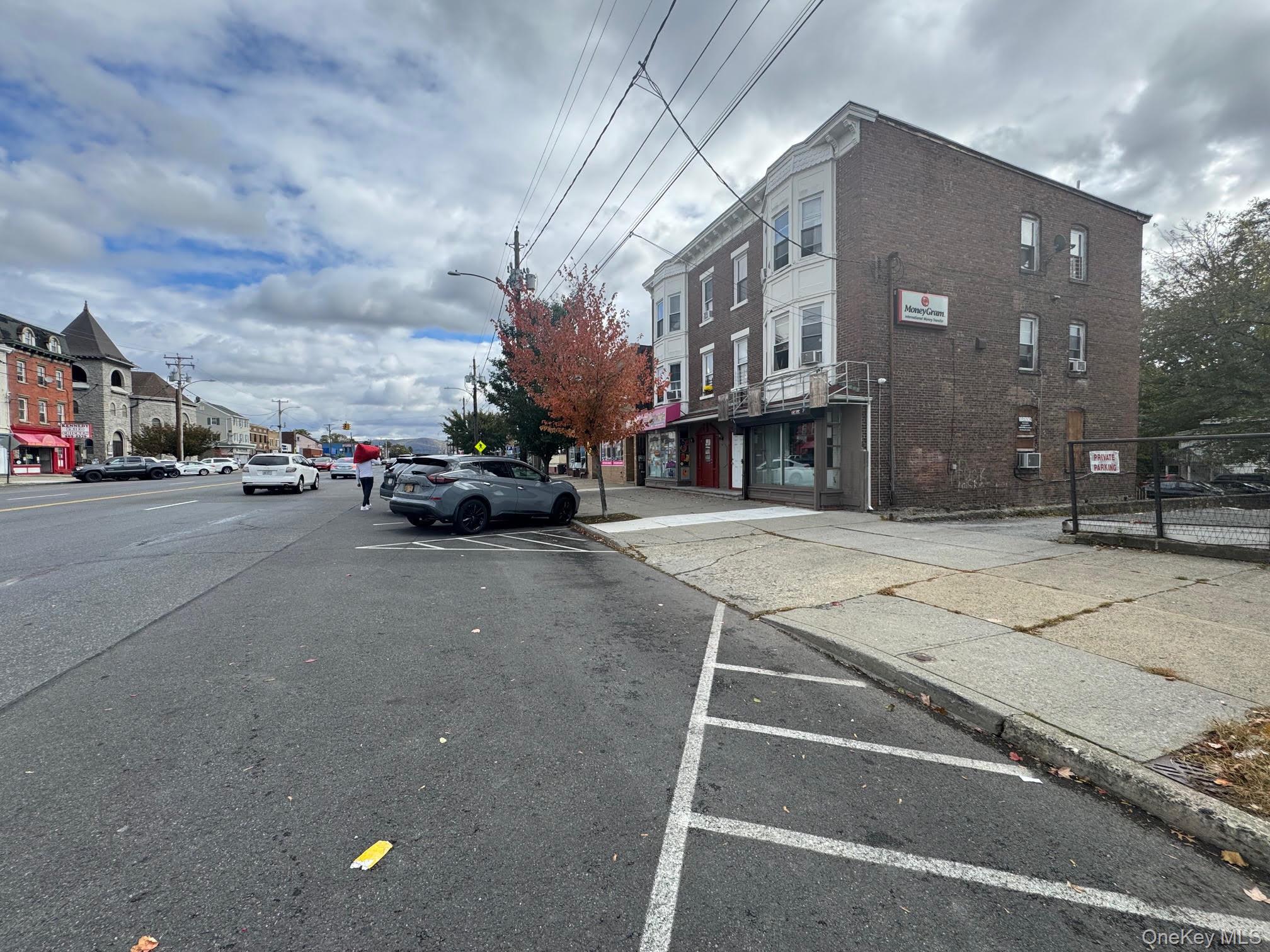 View of asphalt street with curbs, sidewalks, and street lights