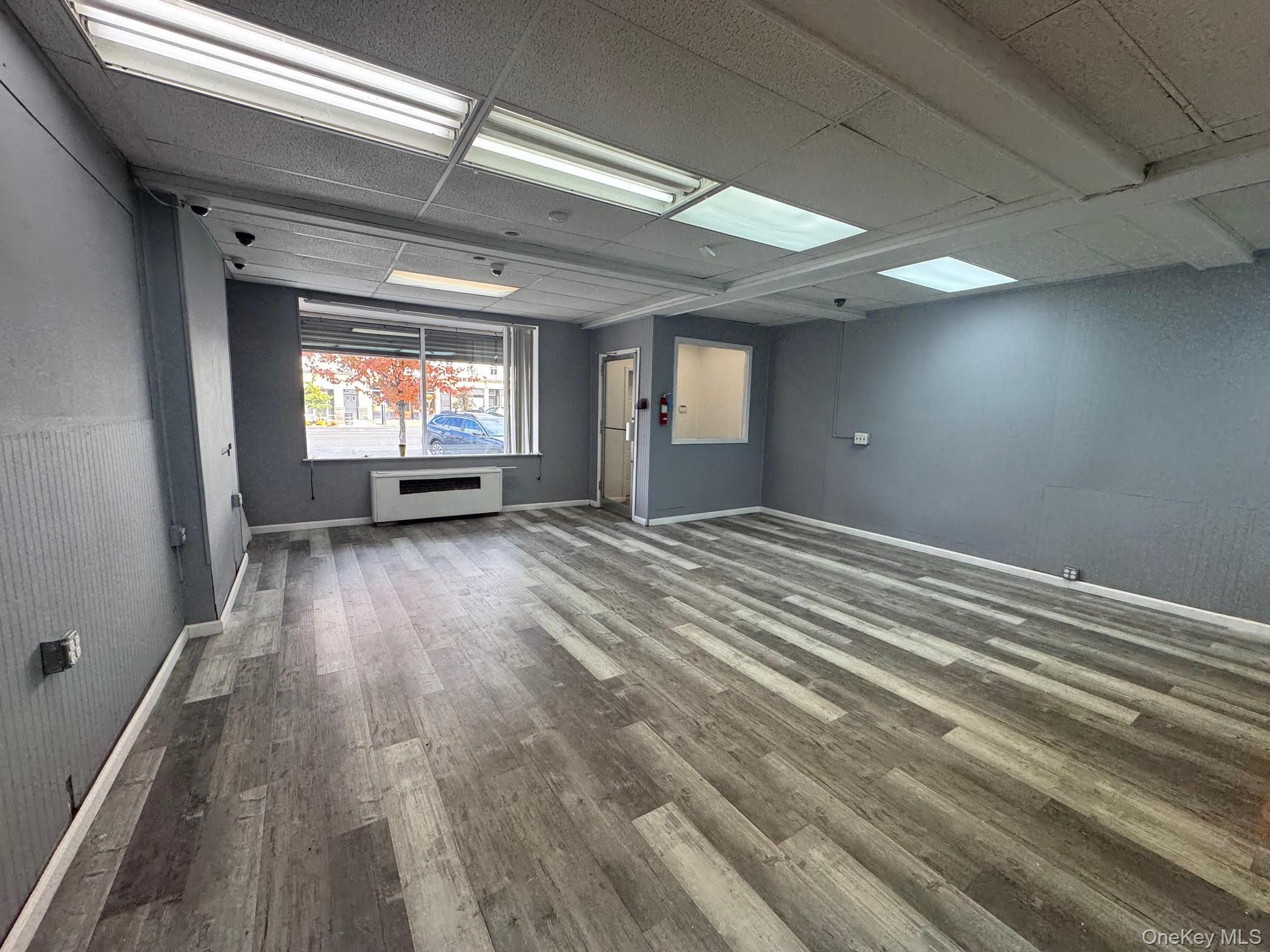 Spare room with wood finished floors and a drop ceiling