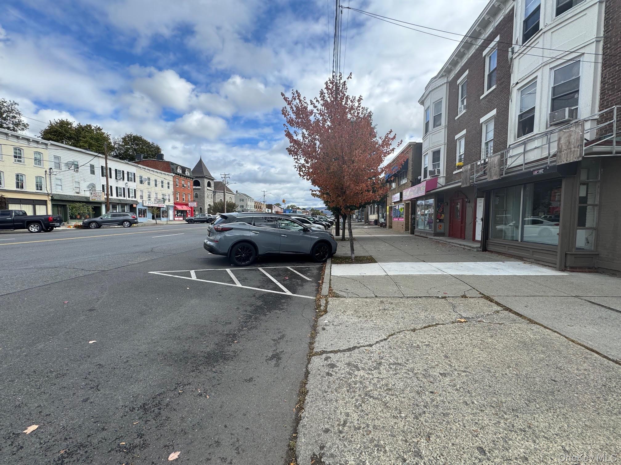 View of asphalt road with sidewalks, street lights, and curbs