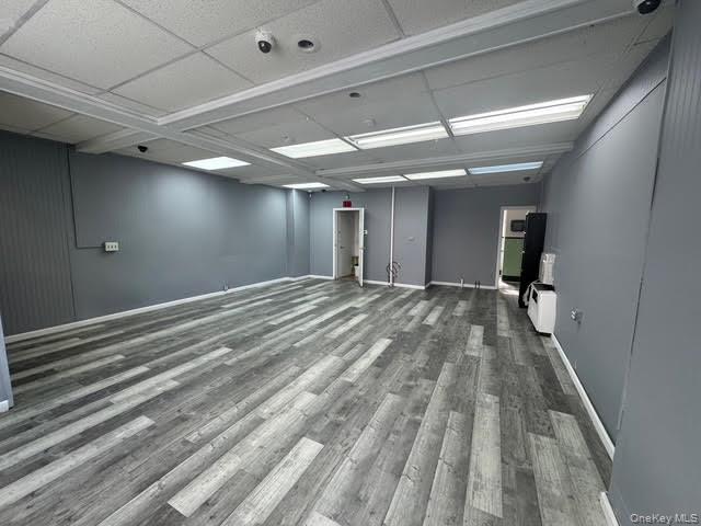 Empty room featuring dark wood-style flooring and baseboards