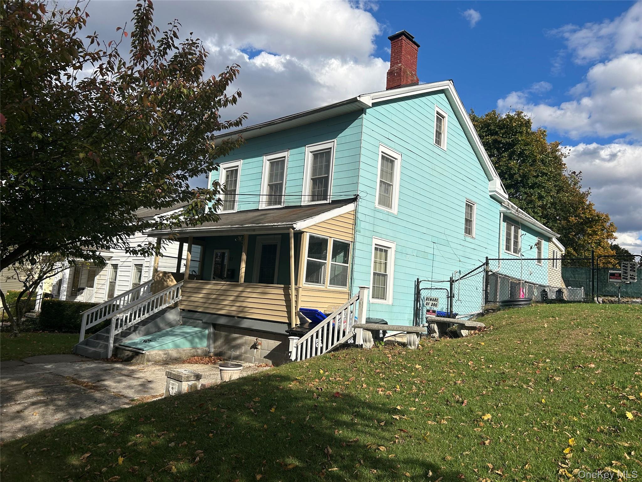 front side of house with a yard and a chimney