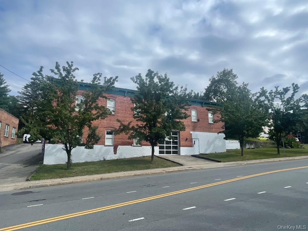 View of asphalt street featuring curbs and sidewalks