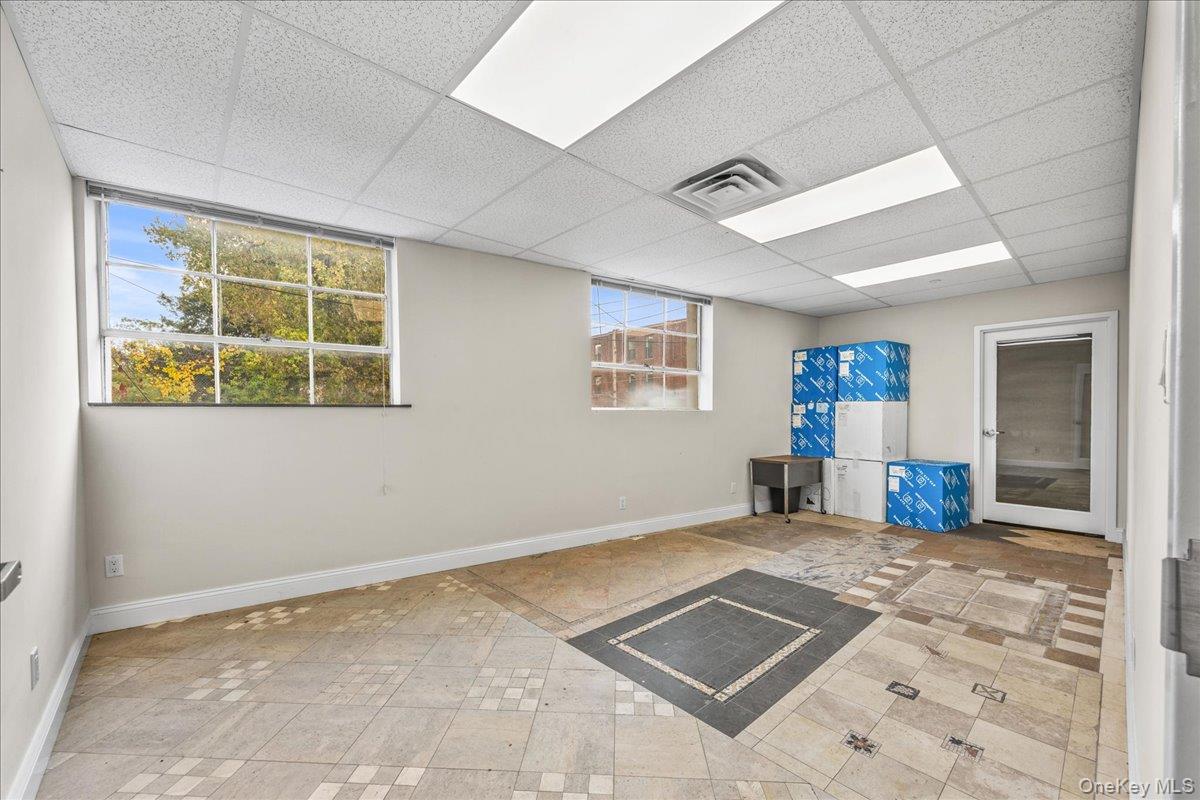 Basement with a drop ceiling and baseboards