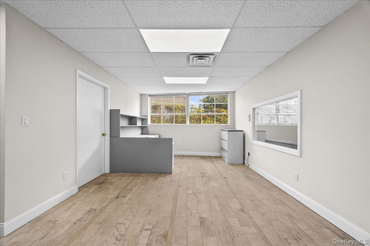 Washroom with light wood-style flooring and a paneled ceiling