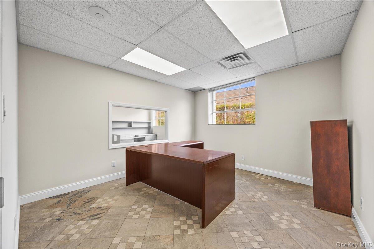 Office area with baseboards and a paneled ceiling
