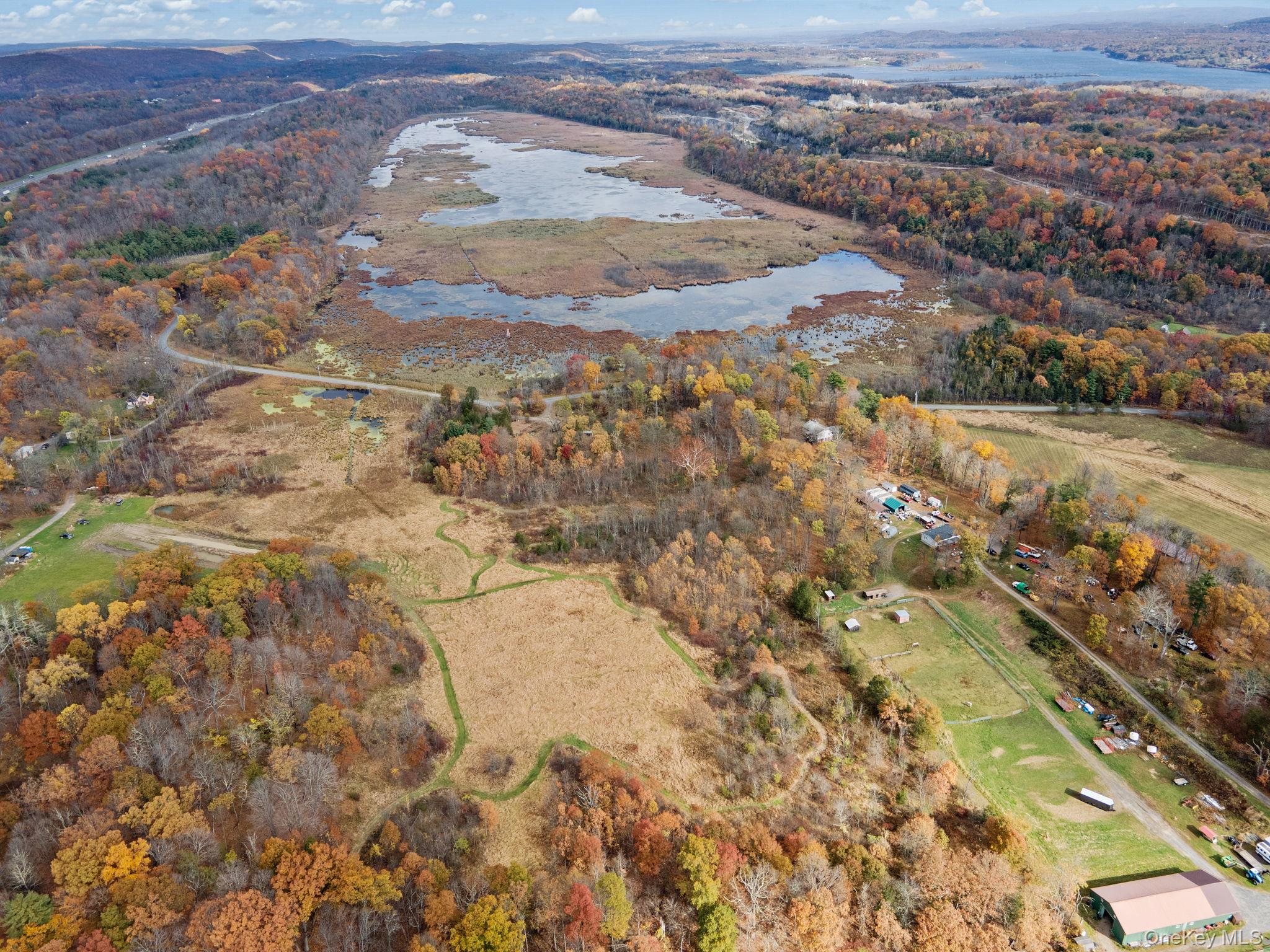 Aerial view of property's location with a large body of water and a forest