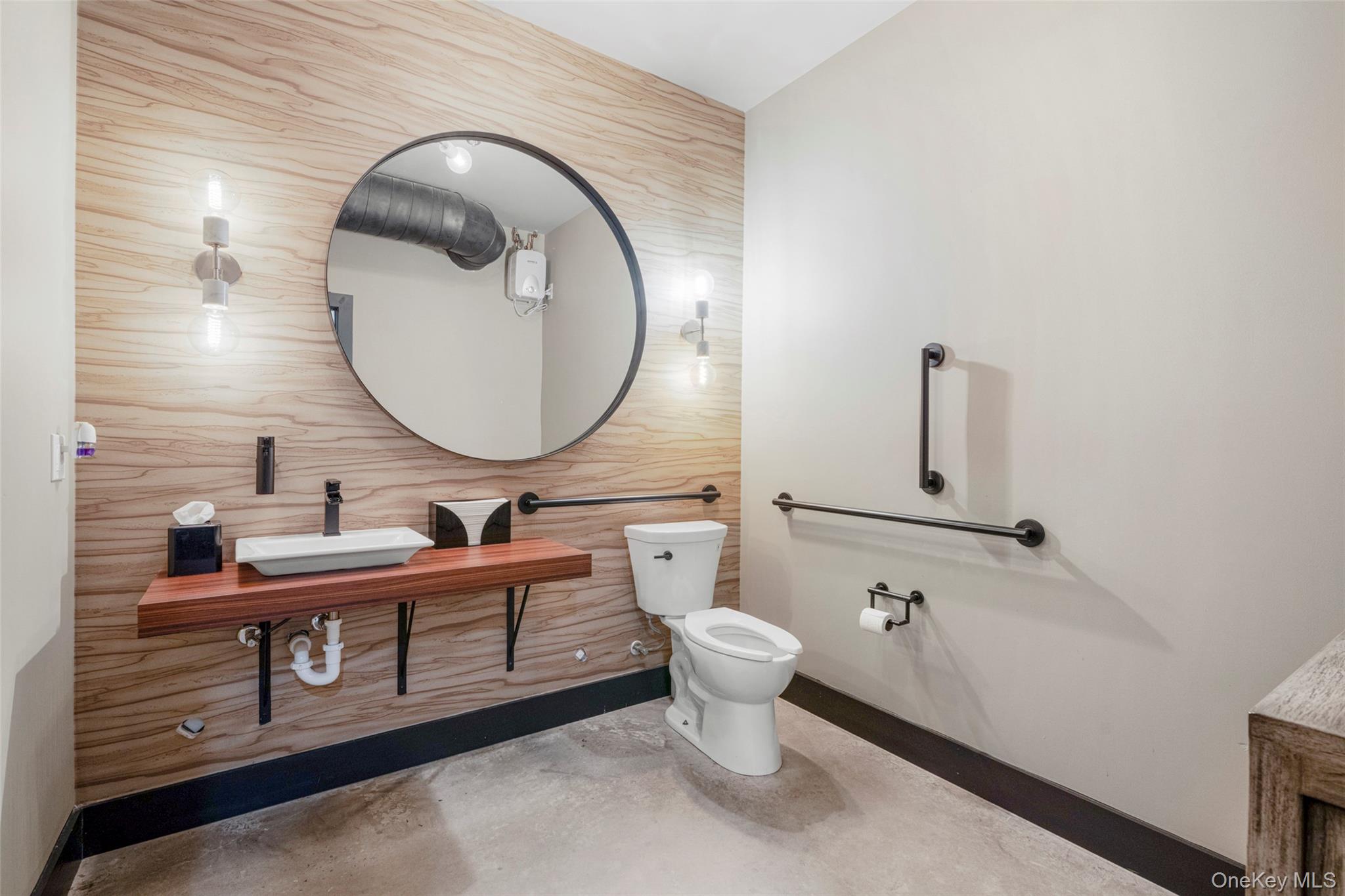 Bathroom featuring tile walls, vanity, and concrete floors