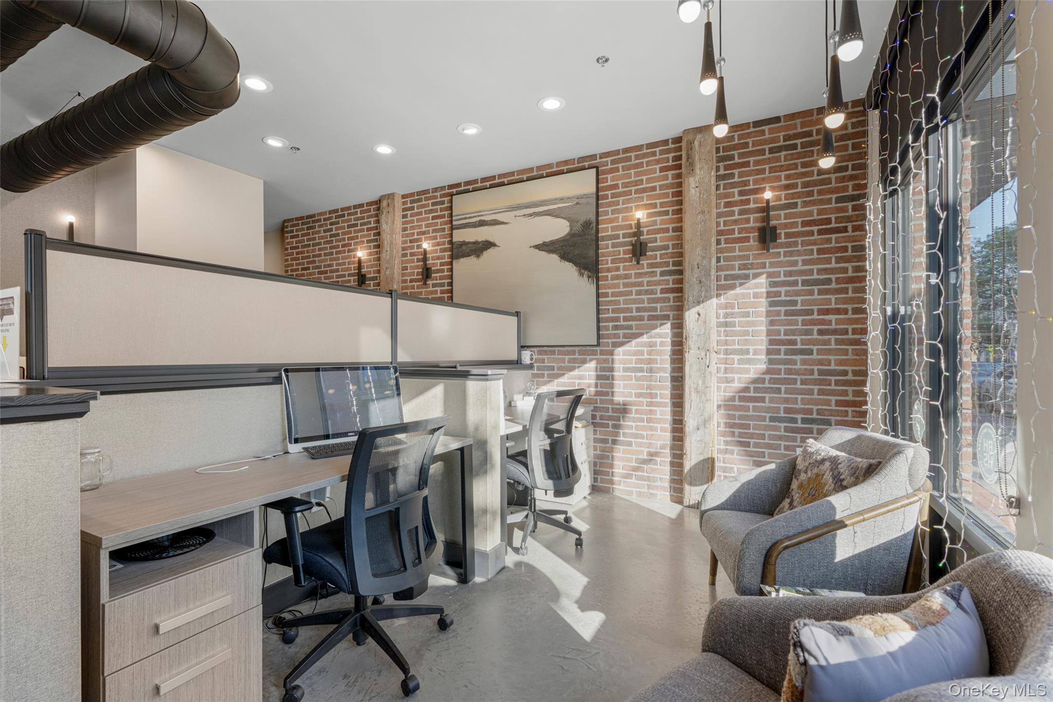 Office with brick wall, recessed lighting, and plenty of natural light