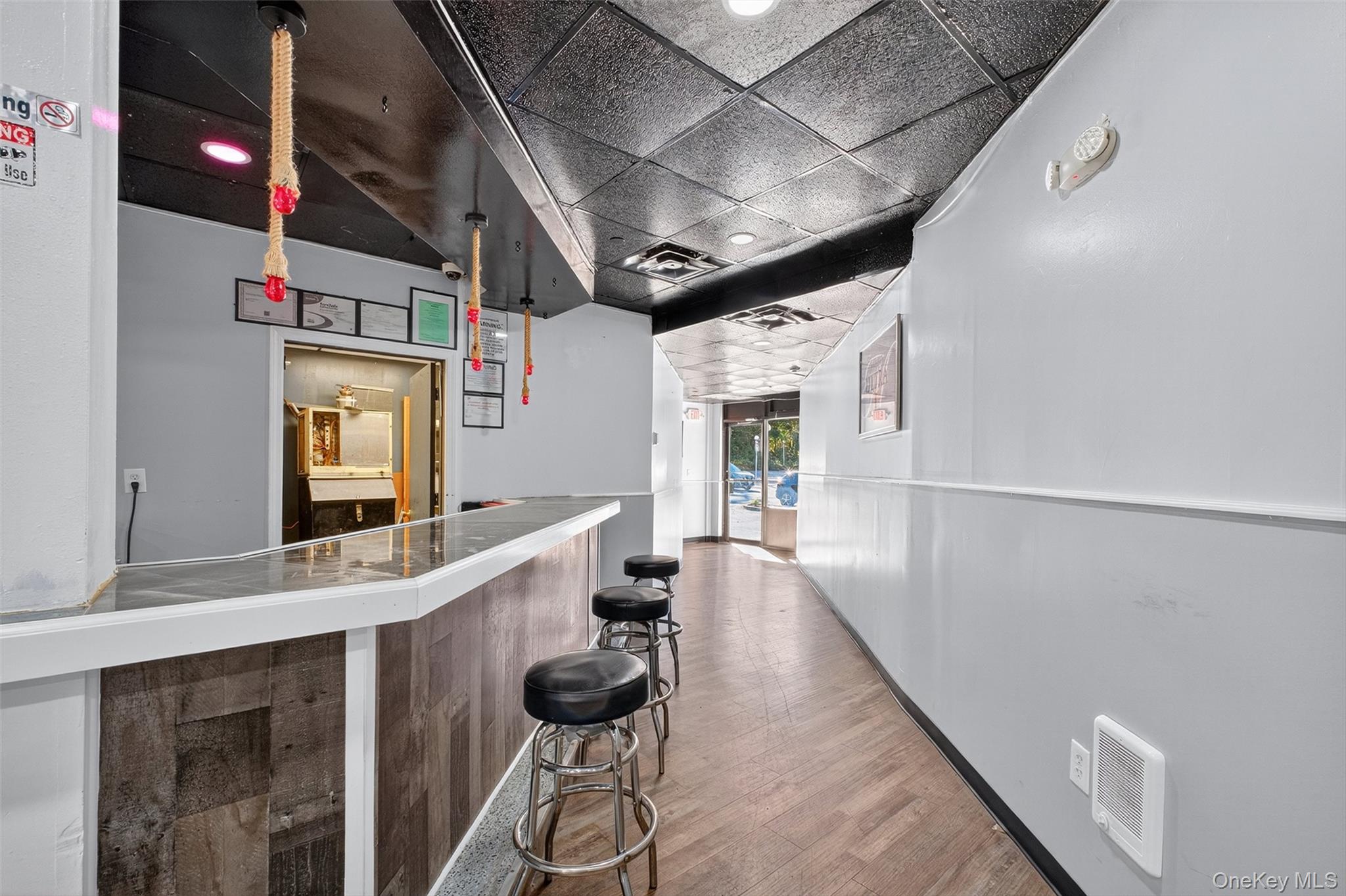 Indoor dry bar featuring a paneled ceiling and recessed lighting