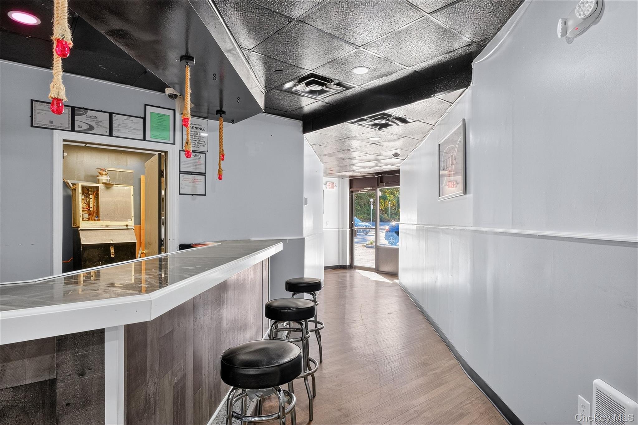Reception area with a paneled ceiling, a bar, and a wainscoted wall