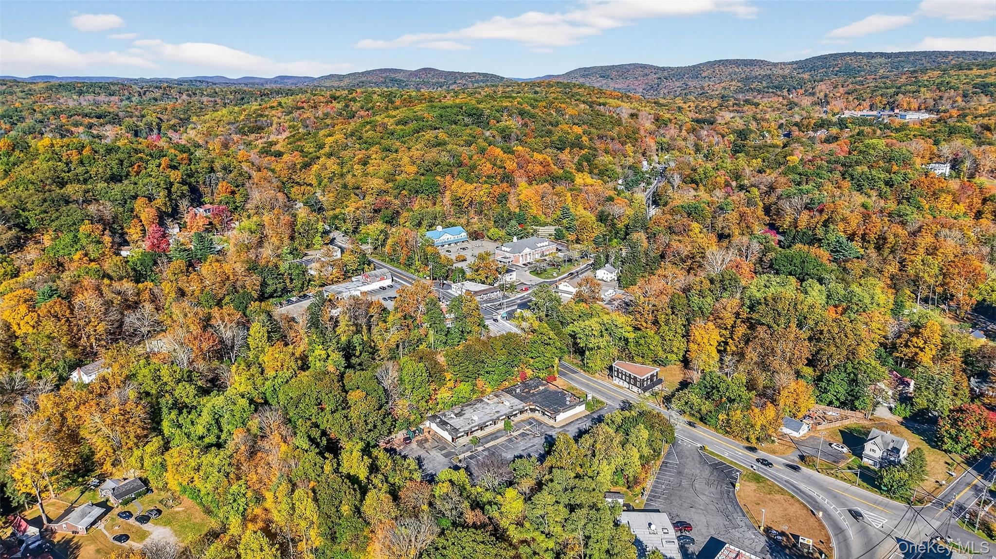 Aerial view of property and surrounding area with a heavily wooded area