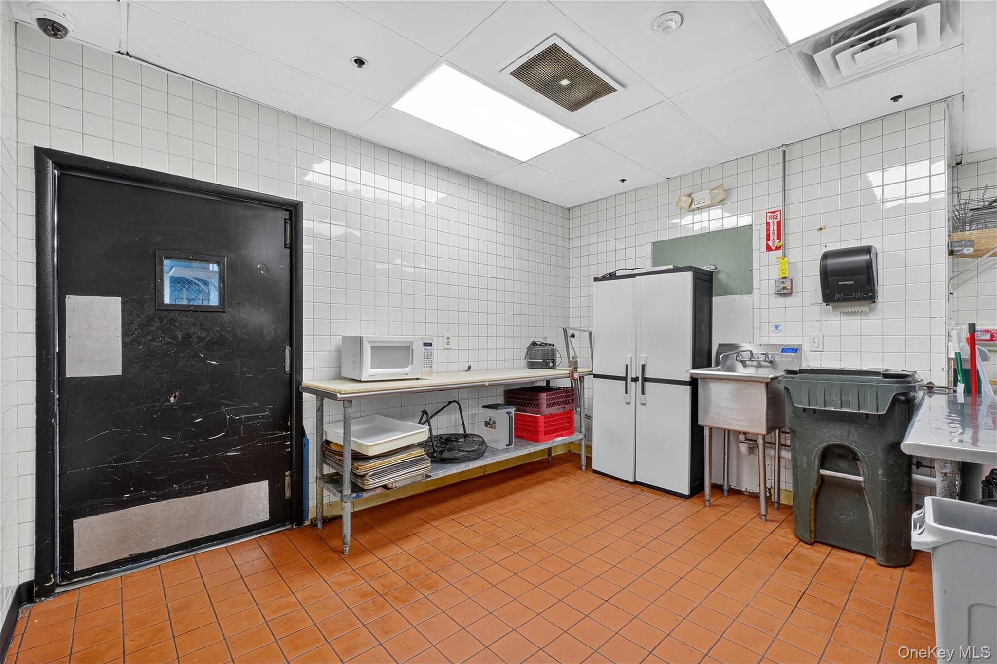 Kitchen with tile walls and white microwave