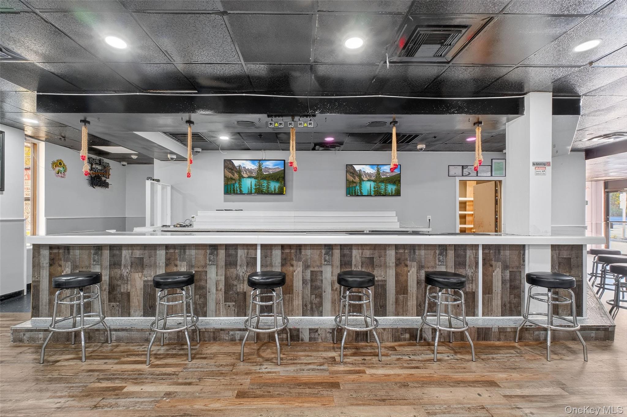Indoor wet bar featuring recessed lighting and light countertops