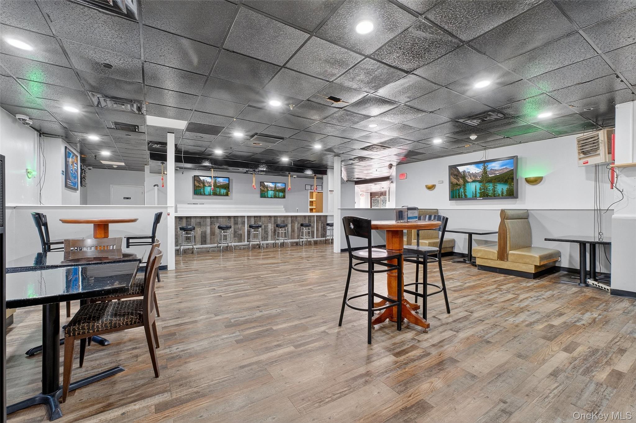 Dining space with light wood-type flooring and a paneled ceiling