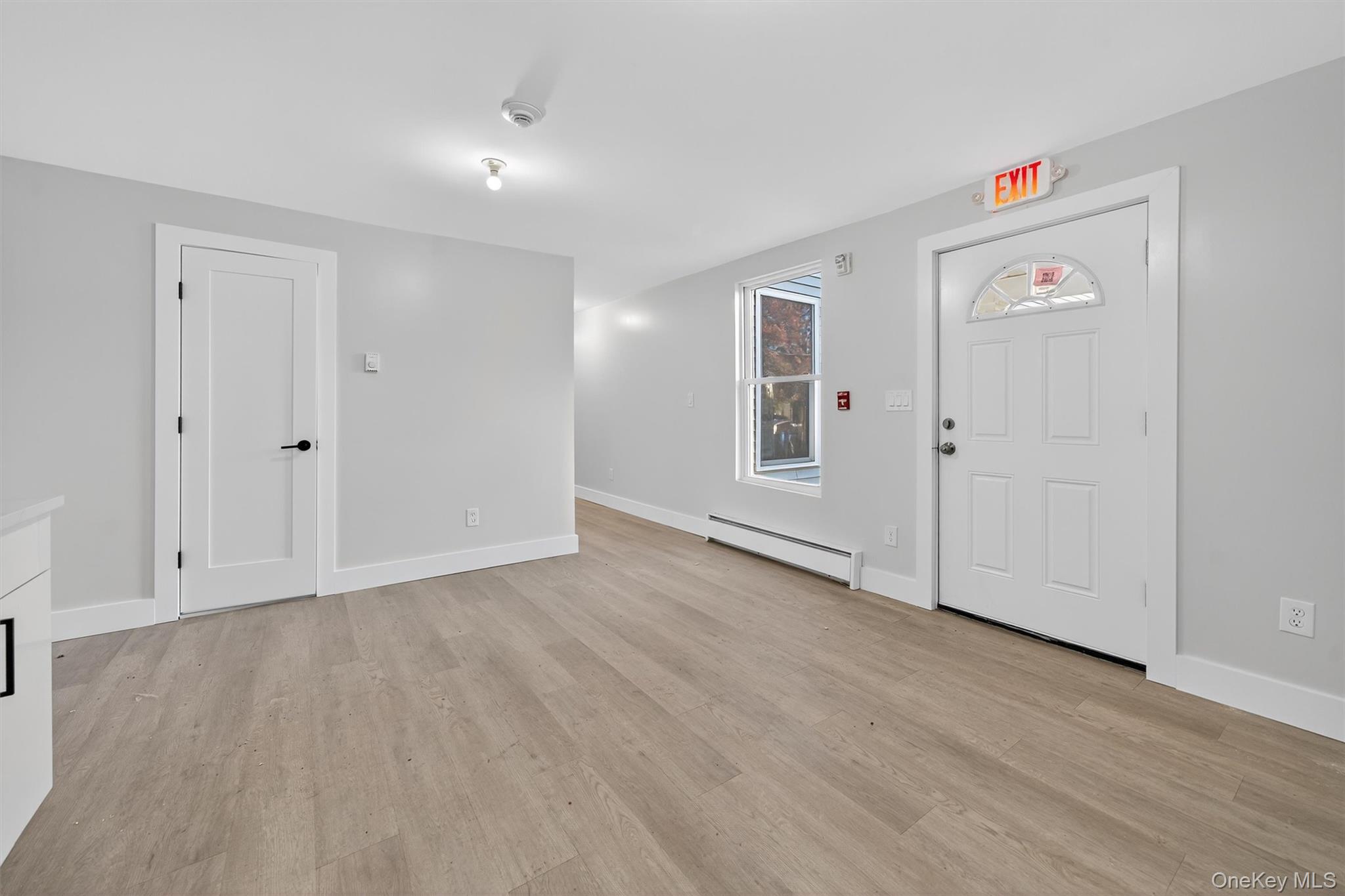 Entrance foyer featuring baseboard heating and light wood-style floors