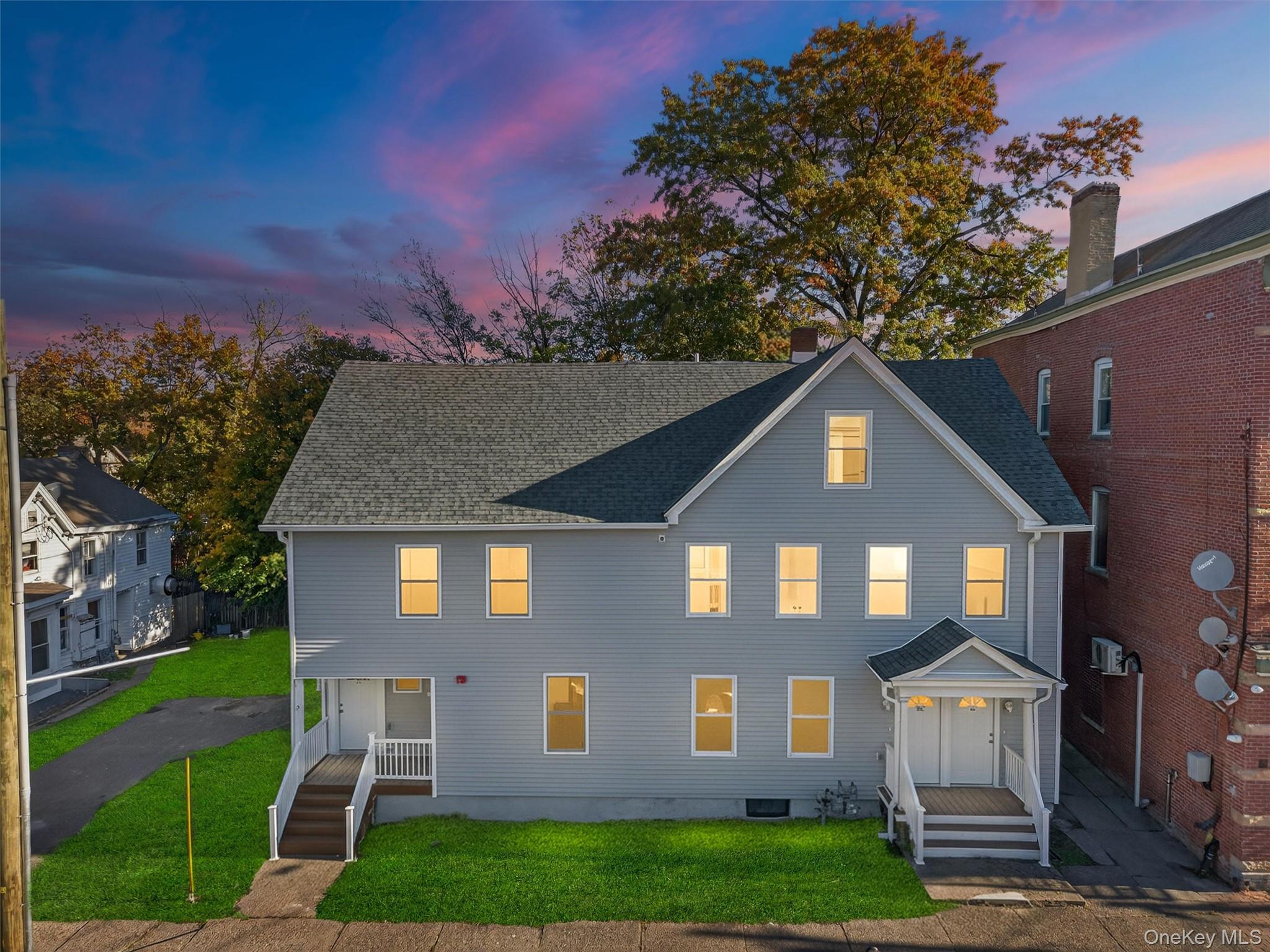 View of front of property featuring a front yard and roof with shingles