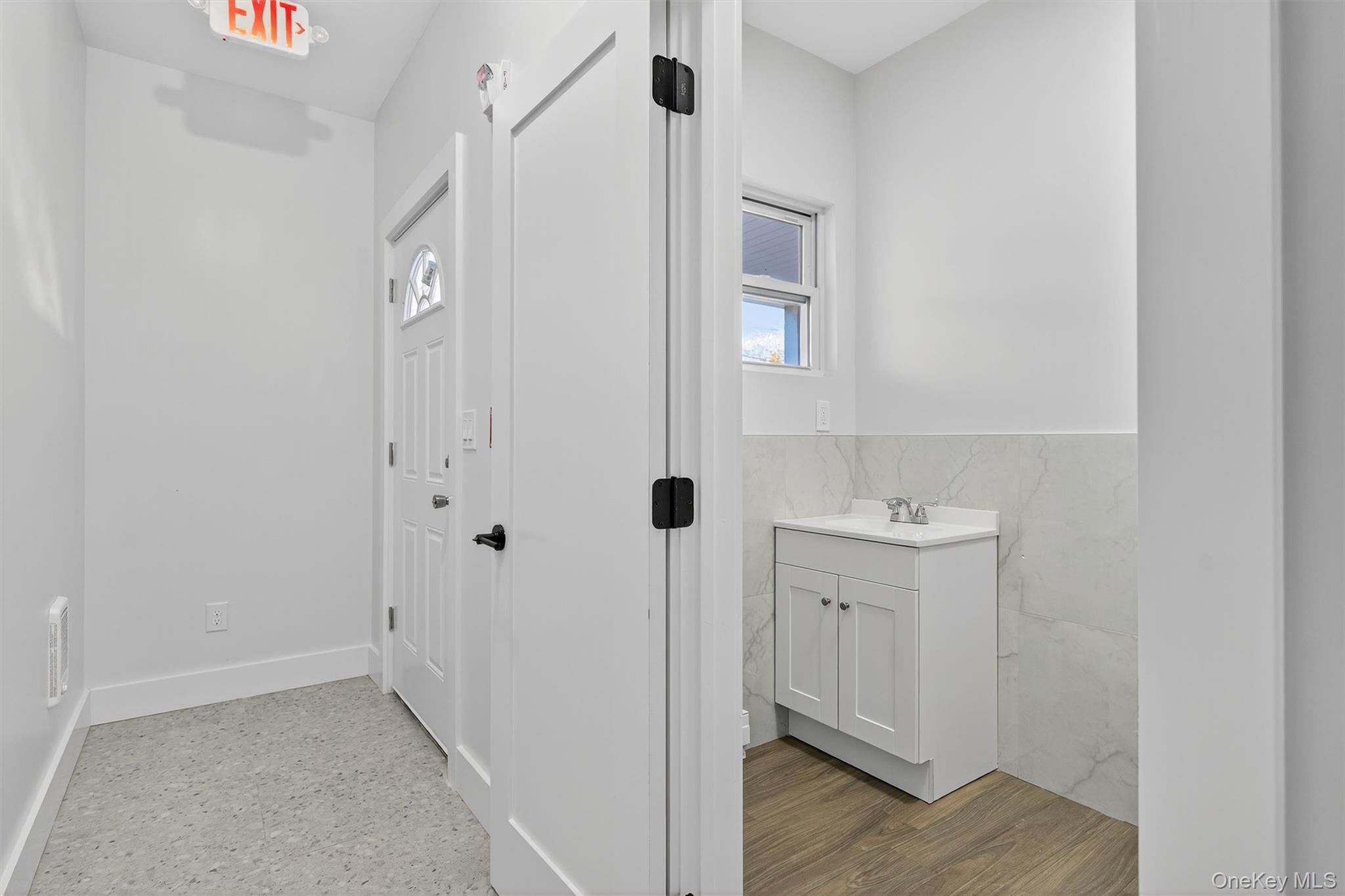 Bathroom featuring vanity, tile walls, and wainscoting