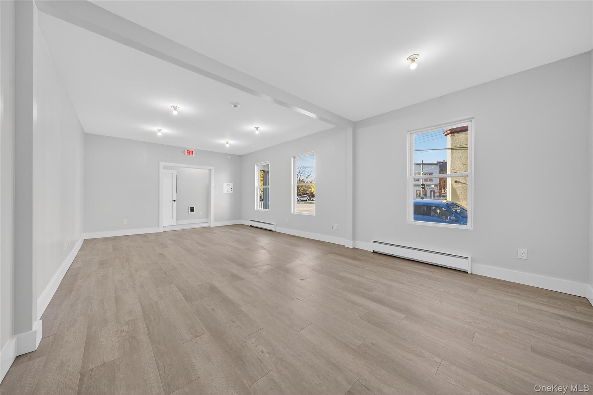Empty room featuring light wood-style flooring and a baseboard radiator