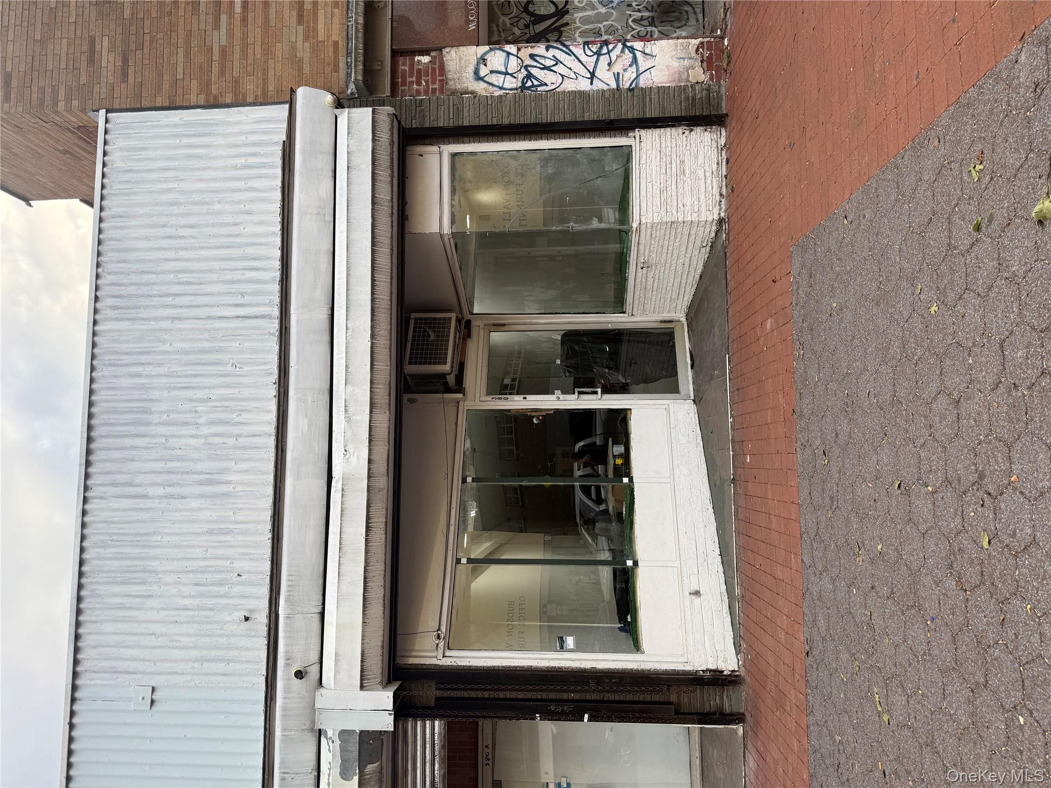 Doorway to property featuring brick siding and a wall unit AC