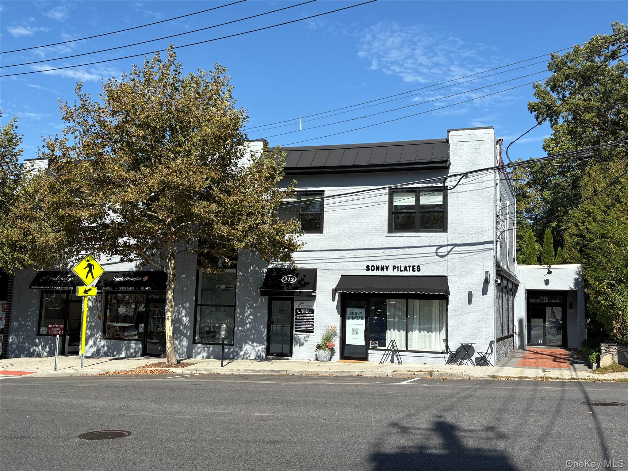 View of front of home featuring brick siding and a metal roof