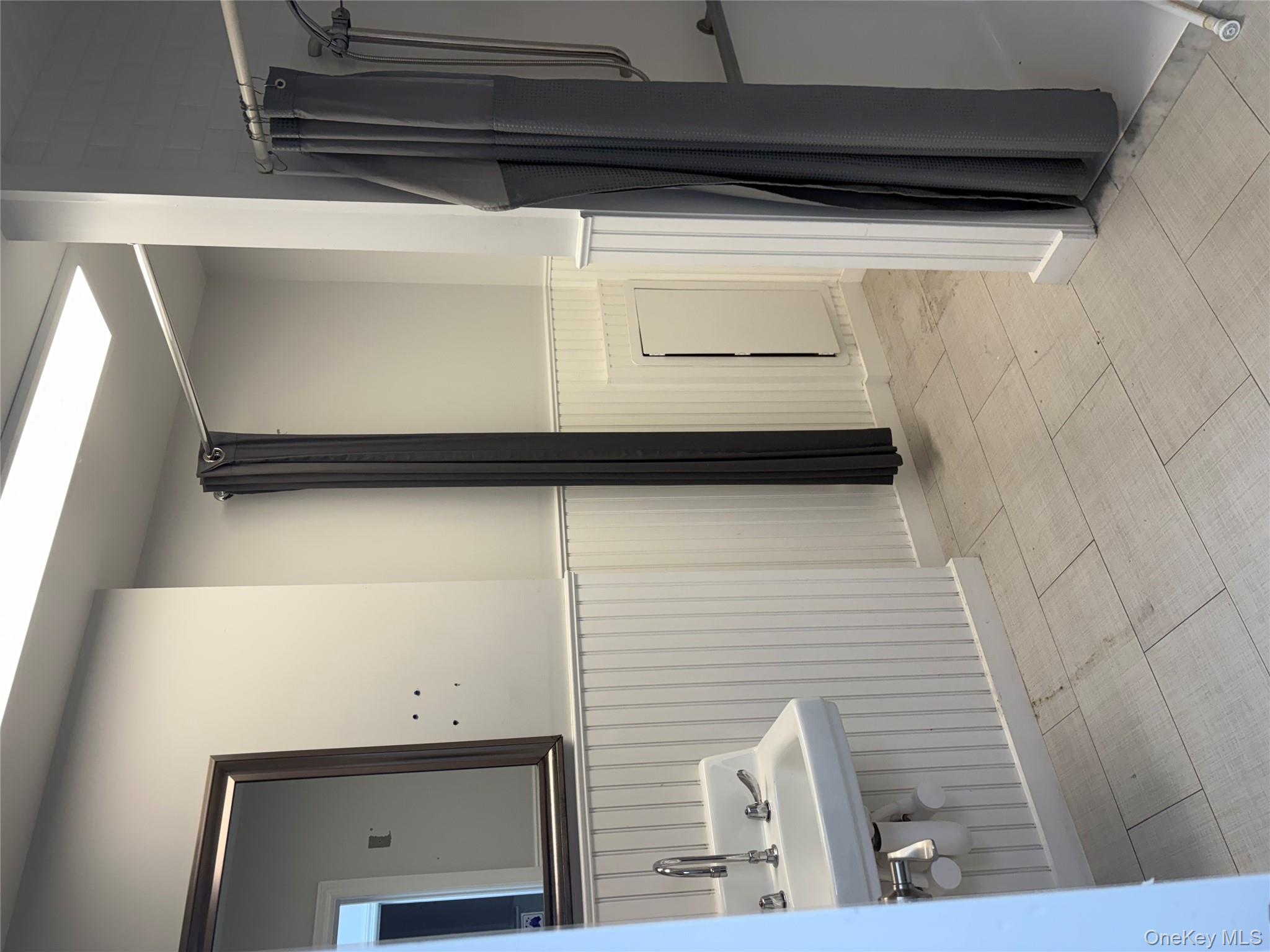 Full bath with wainscoting and a shower stall