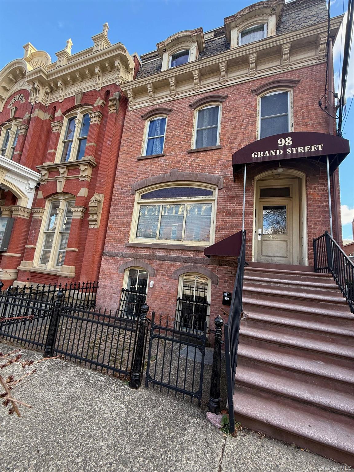 View of front of home with a gate, brick siding, and a fenced front yard