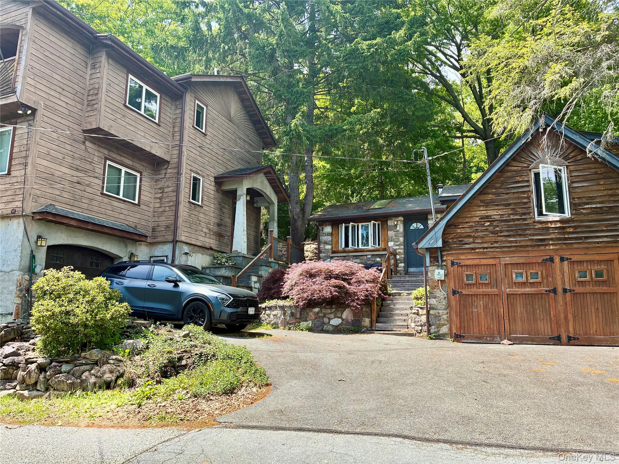 Two homes  - on left contemporary 2 br plus large den, open living room kitchen, garage, fireplace. Master bedroom with vaulted ceilings balcony and large ensuite bathroom. On right stone cottage with 1 br plus office, living room with lake views, skyligh