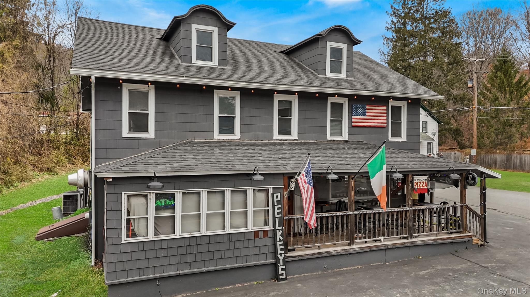 View of front of home featuring roof with shingles and a porch