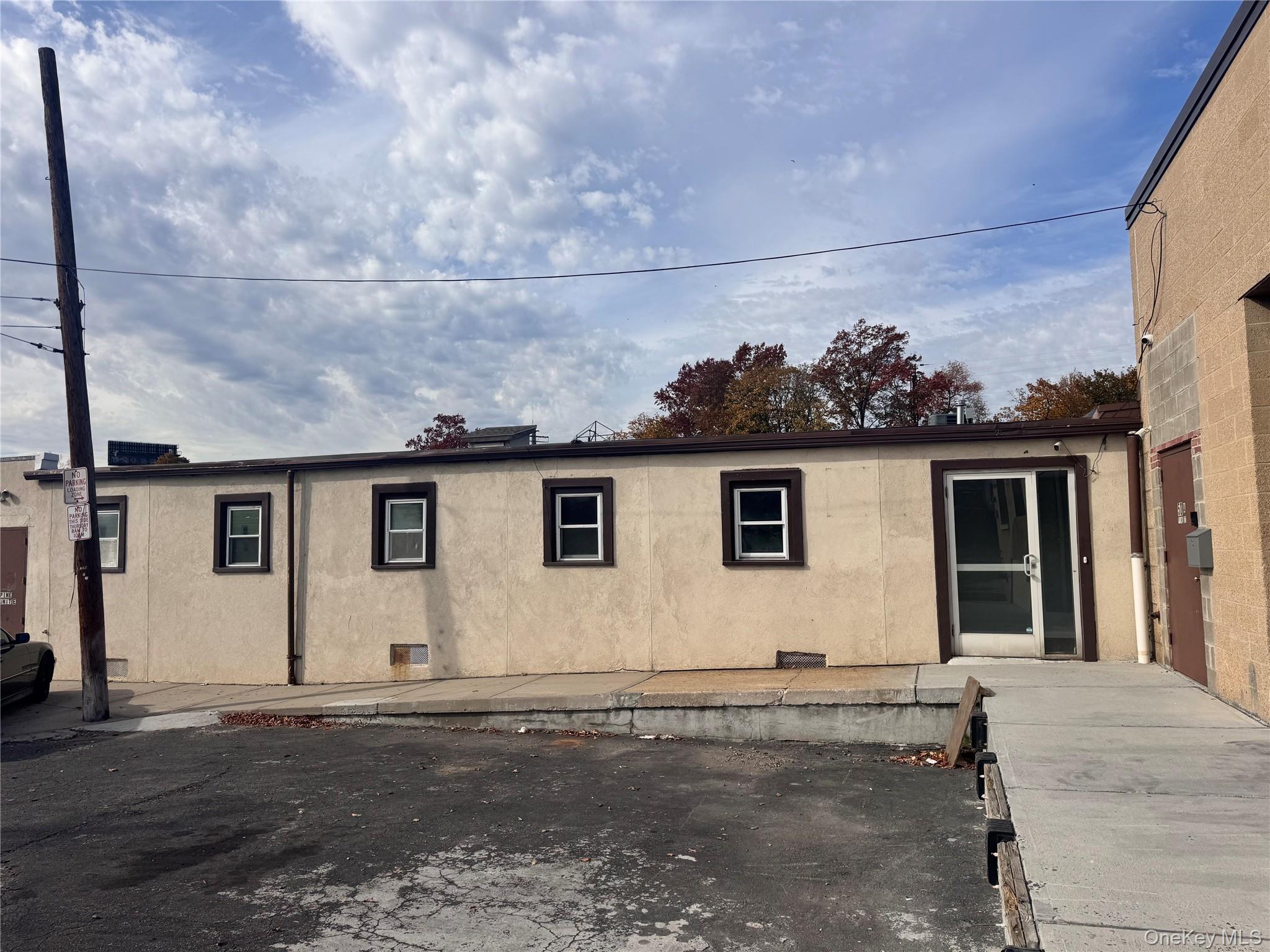 View of side of property with stucco siding and a patio