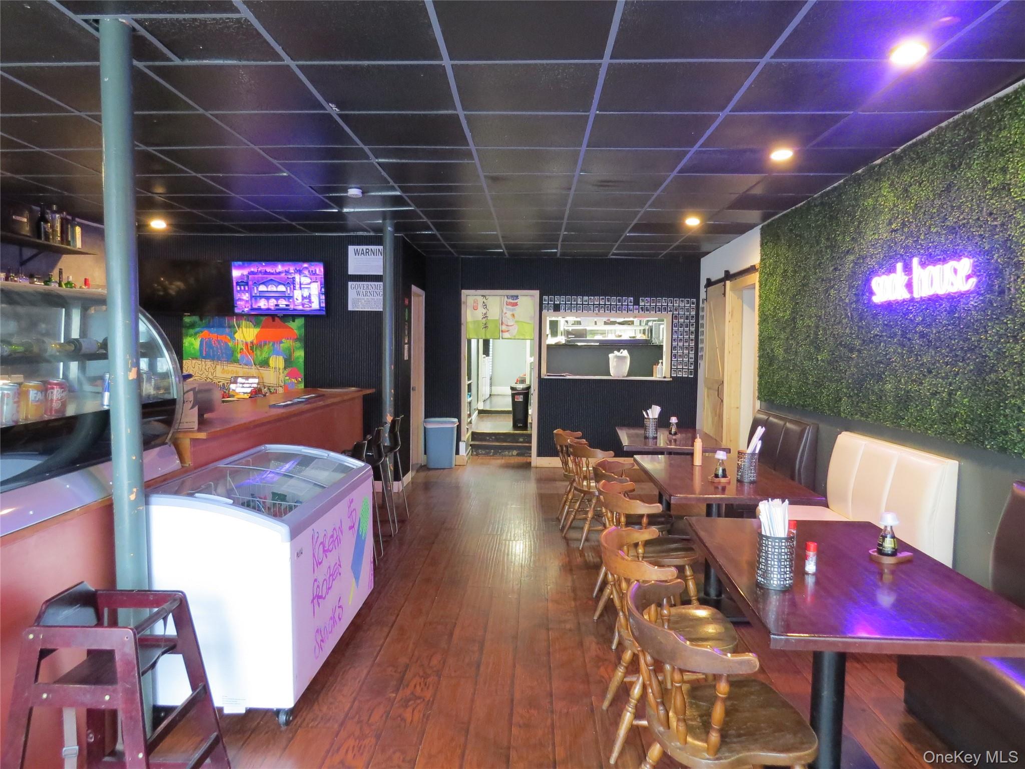Dining space with dark wood-style floors and a drop ceiling