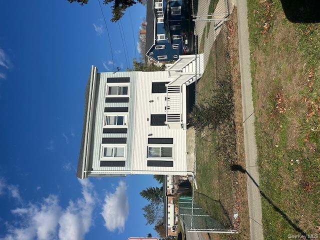 View of front of home with a gate and a wooden deck