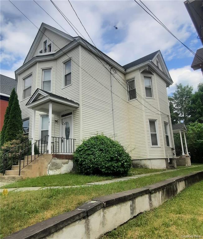 View of side of home with a lawn