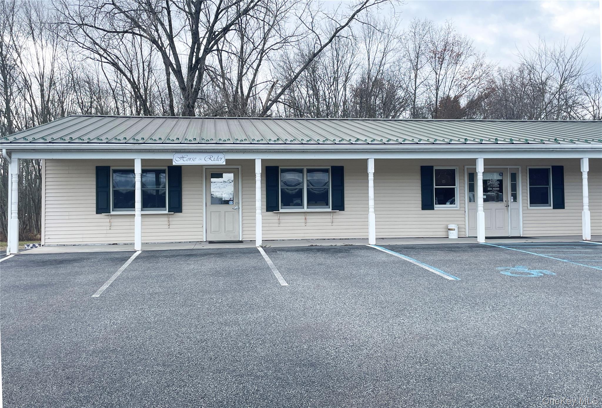 View of front of property featuring a metal roof, uncovered parking, and a porch
