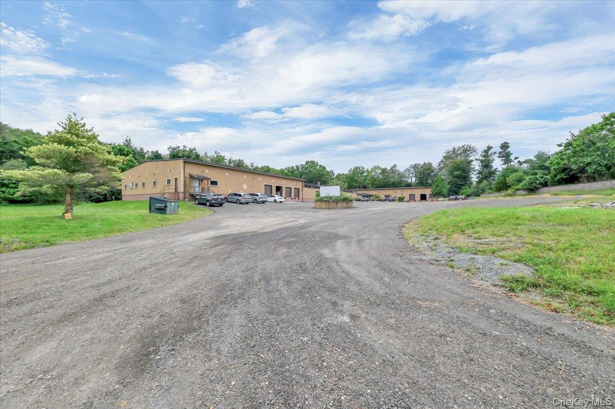 View of front of home featuring view of scattered trees and uncovered parking