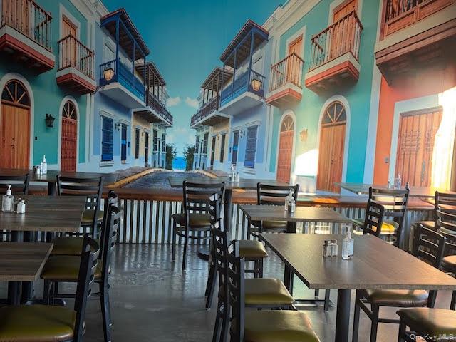Dining area featuring a towering ceiling and finished concrete flooring