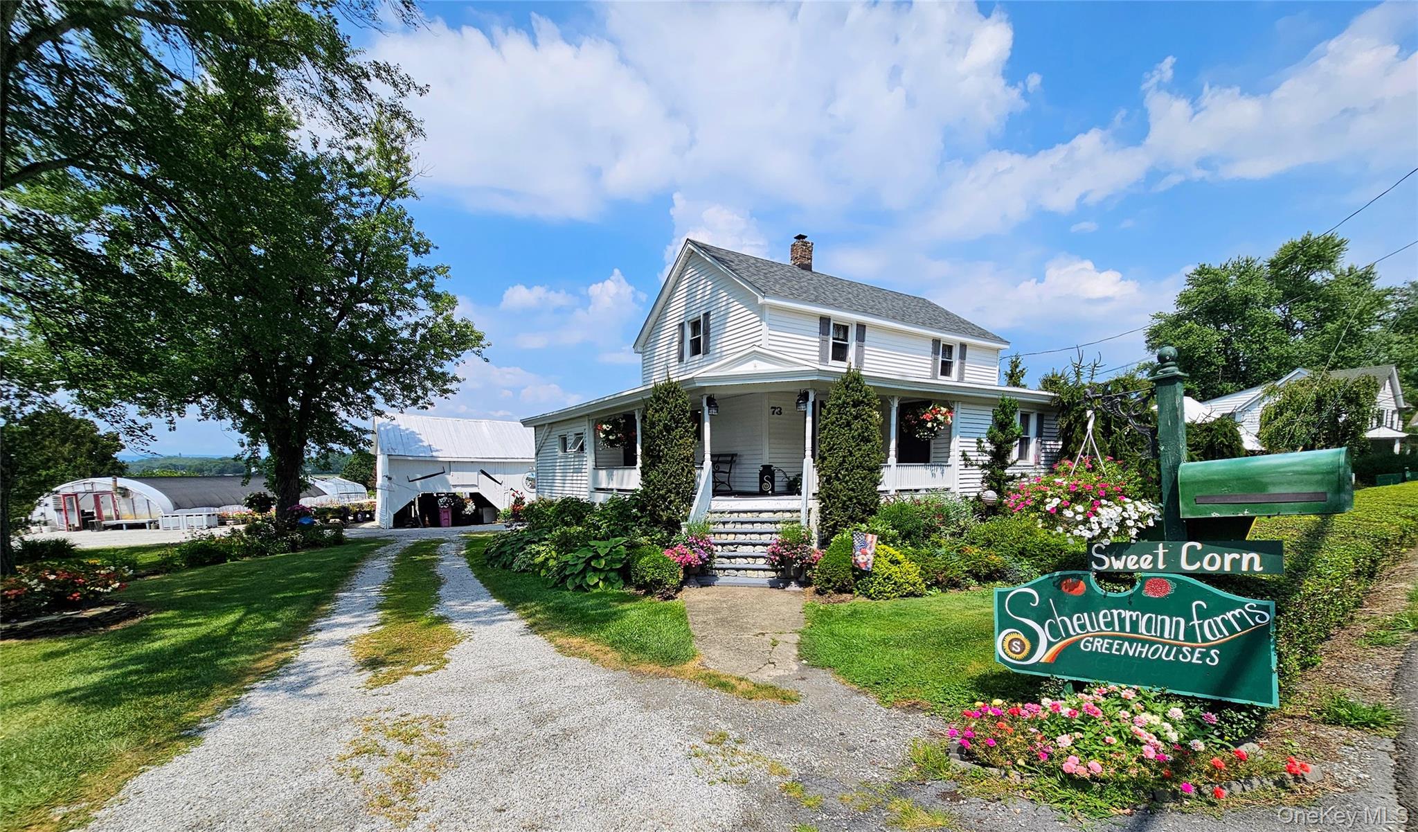 Farmhouse inspired home with a porch, stairway, a chimney, and a front yard