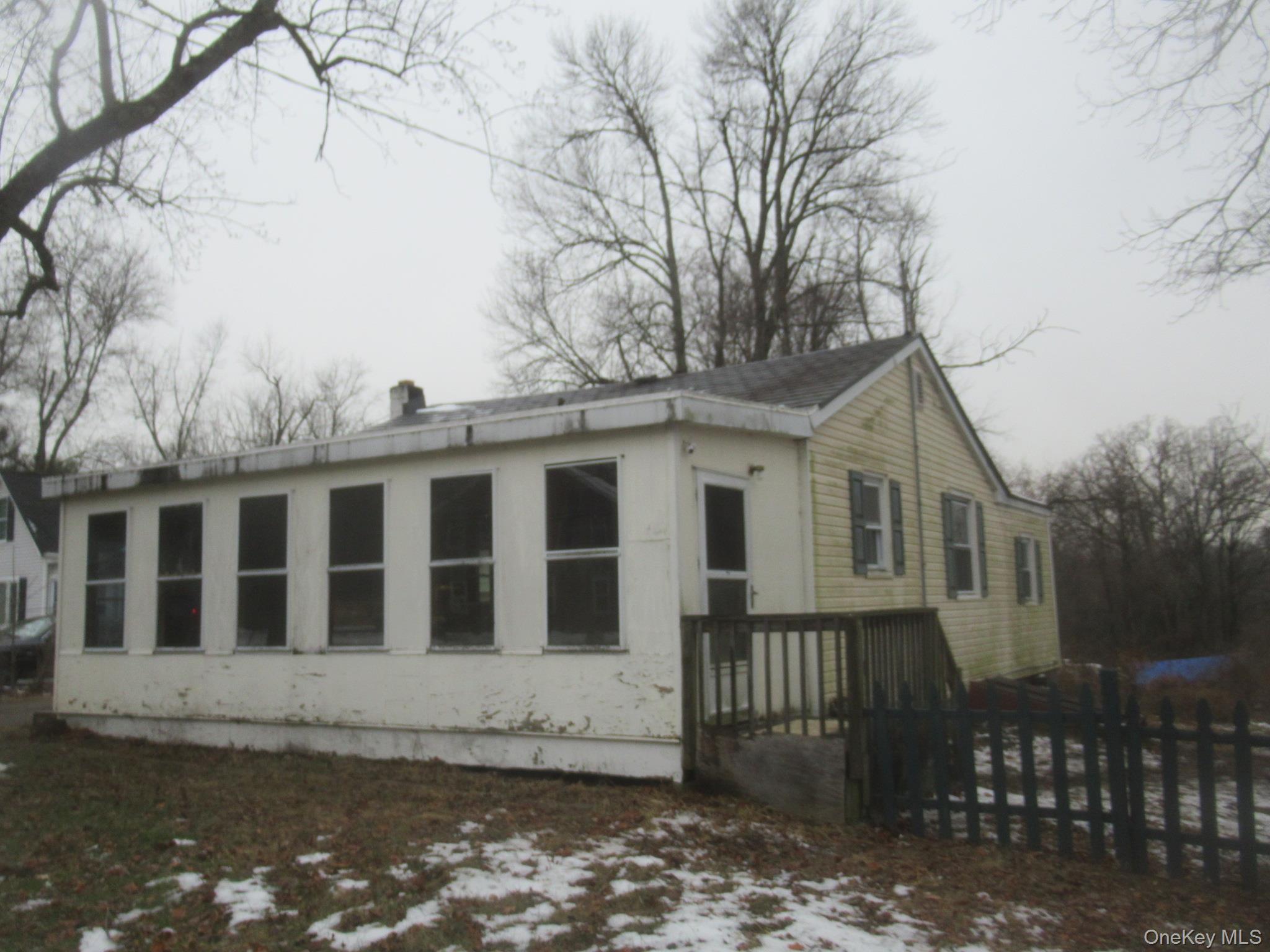Snow covered property featuring a wooden deck and a chimney