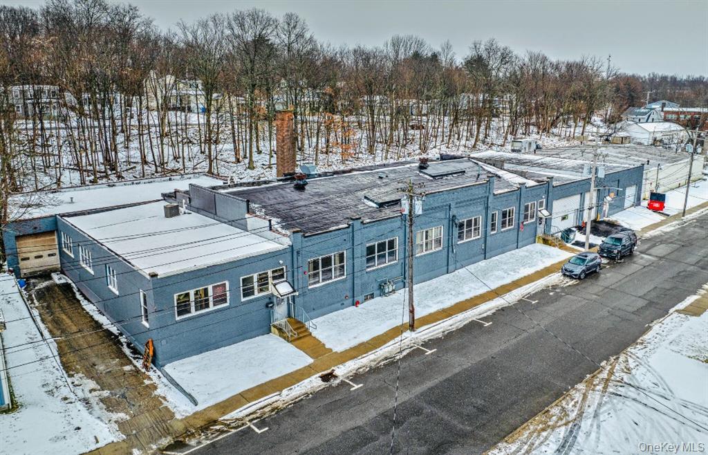 Snowy aerial view with view of wooded area