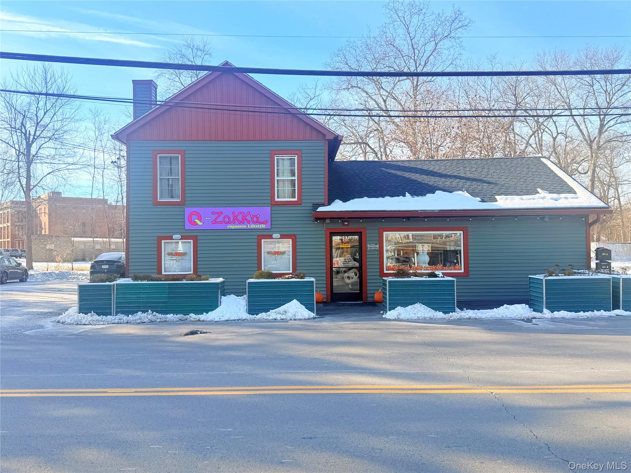 View of front facade with a chimney and a shingled roof