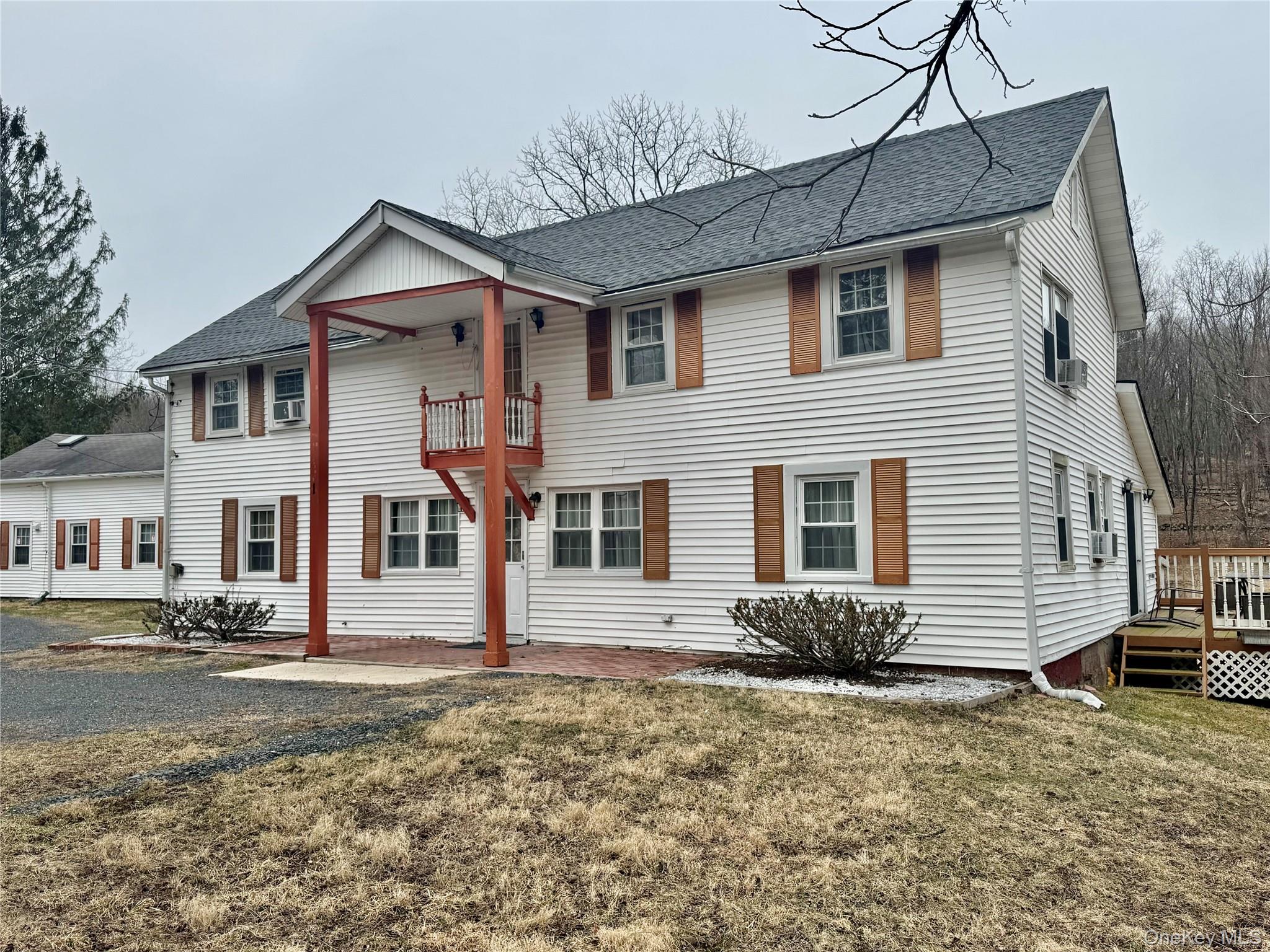 1 - Colonial home featuring a balcony, a front lawn, and roof with shingles