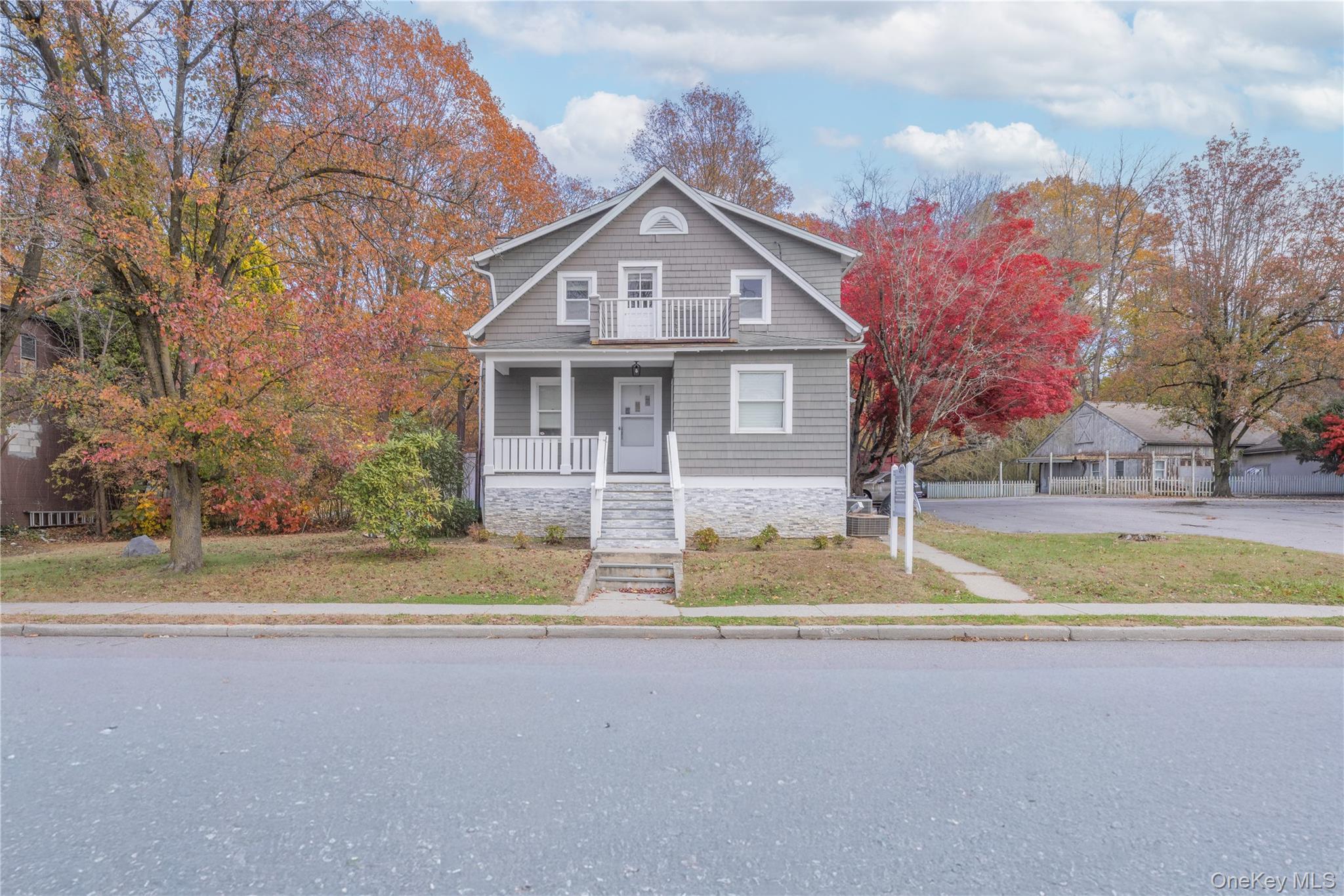 View of front of property featuring stone siding and a porch