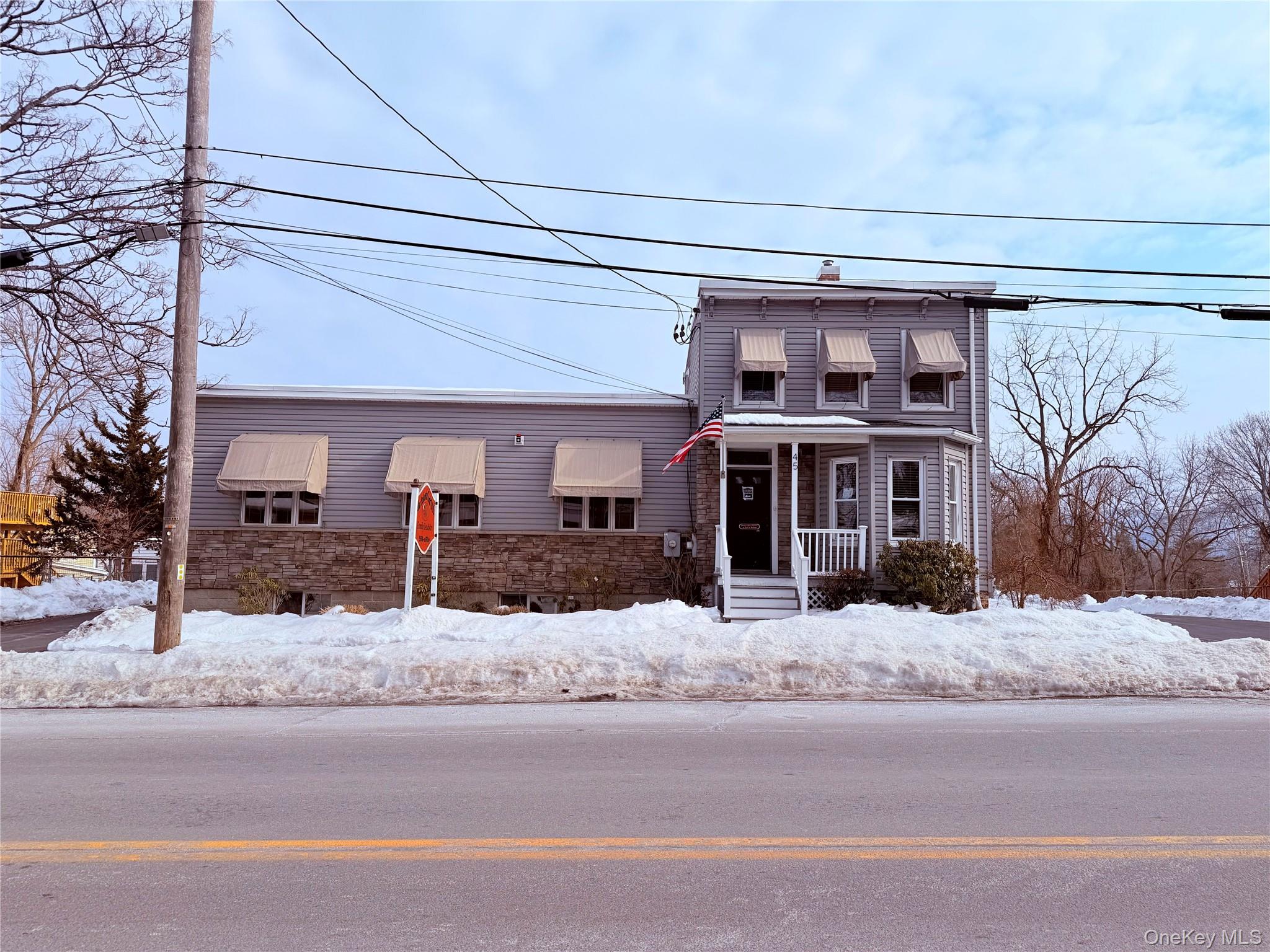 View of front of home with stone siding and a porch