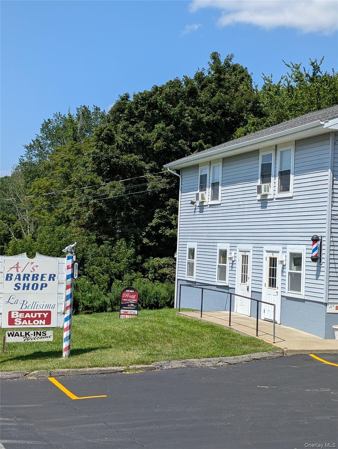 View of front facade with a front yard with newly paved and designated parking