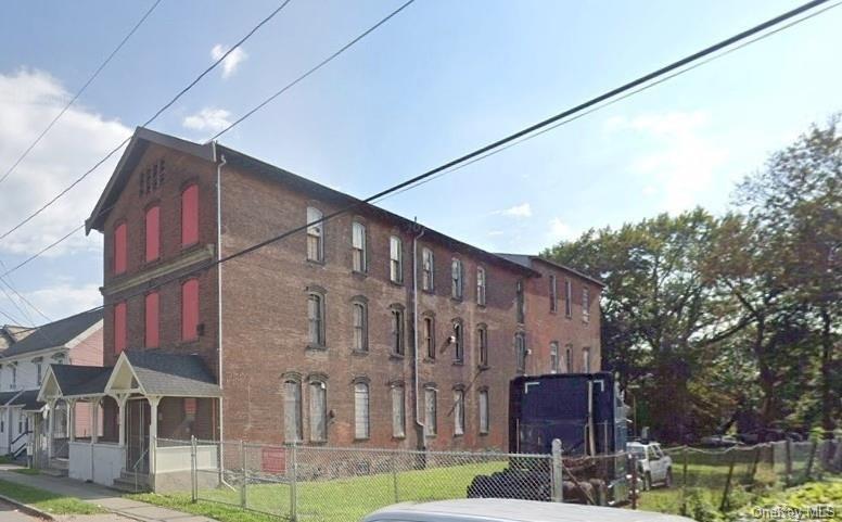 View of building exteriorfeaturing a fenced front yard