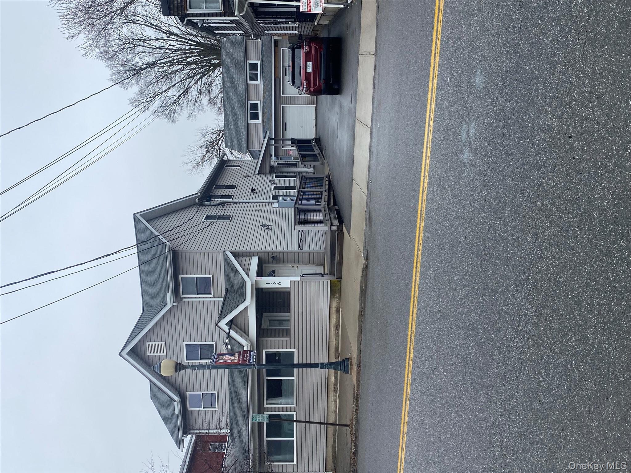 Multi unit property featuring a garage, an outdoor structure, and concrete driveway