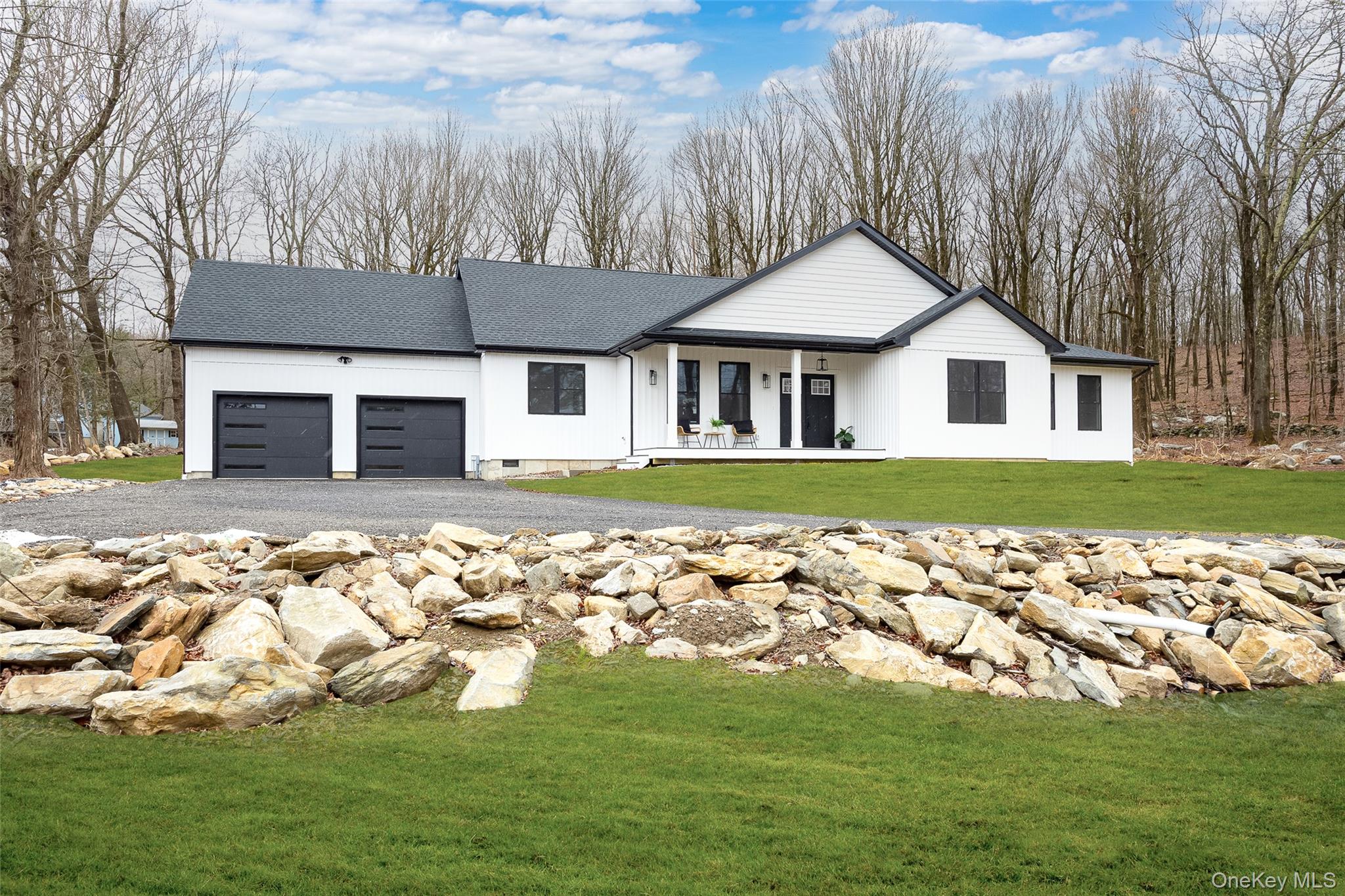 Modern farmhouse style home with a front lawn, crawl space, covered porch, an attached garage, and roof with shingles