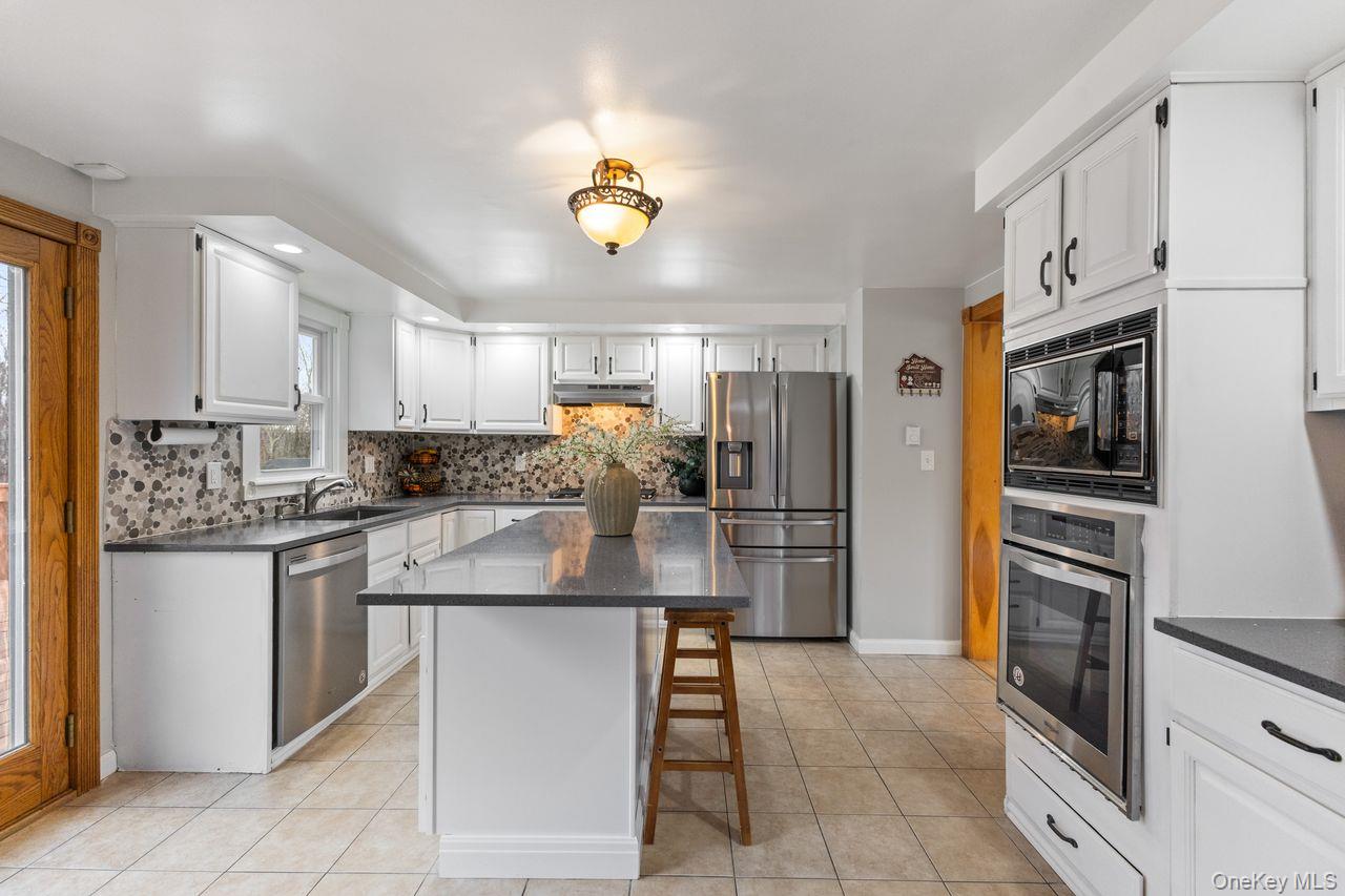 Main floor kitchen. Updated with Quartz countertop center island and stainless steel appliances including 5 burner gas cooktop.