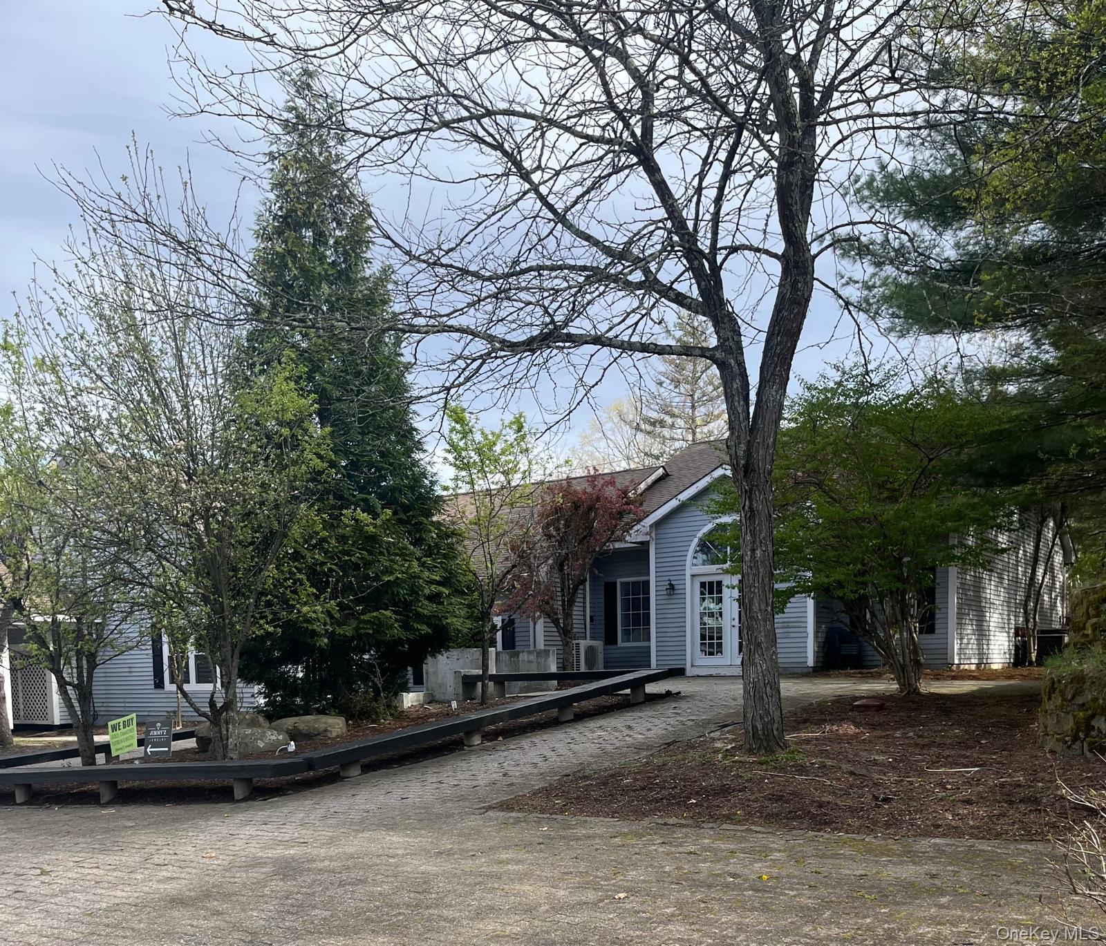 Light blue siding exterior with a white arched entry door and a covered front entry